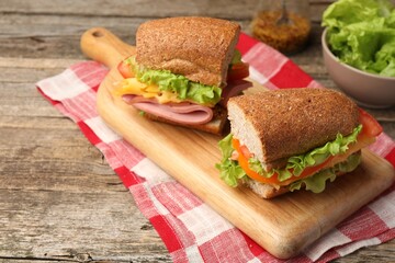 Delicious sandwiches with ham on wooden table, closeup