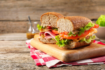 Delicious sandwiches with ham on wooden table, closeup