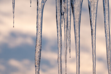 Icicles glistening against a cloudy sky capturing the beauty of winter's cold embrace