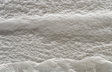Uneven textured white surface illuminated by soft, directional lighting