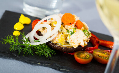 Chicken salad served on ring of grilled eggplant with fresh pepper, onion and tomato