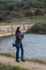 Young woman walking near river in countryside smiling