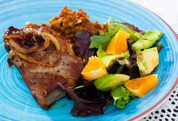 Baked pork shank with lentils and healthy summer salad of avocado, greens and orange ..