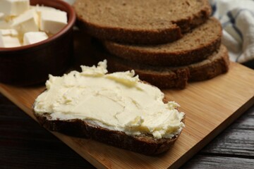 Fresh bread with butter on wooden table, closeup