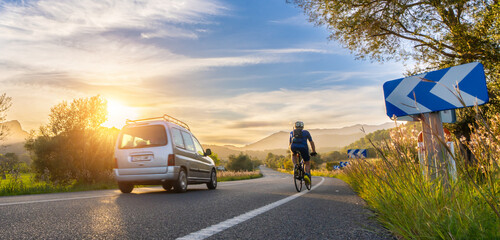 rental car in spain mountain landscape road at sunset overtake a bicycle