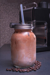Young white-skinned Latina woman making hot drink, American-style coffee with milk and water in a coffee machine in the comfort of her home. She is happy and content.
