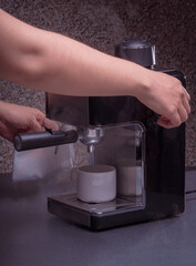 Woman Barista operates a machine to prepare delicious coffee, using the coffee machine