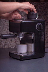 Woman Barista operates a machine to prepare delicious coffee, using the coffee machine