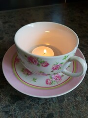 burning candle in a teacup
