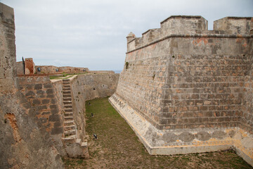 Fortified walls, a turret and the ocean at Castillo del Morro or San Pedro de la Roca fortress XVII century fortress at the entrance of Santiago de Cuba bay. © Alexandre