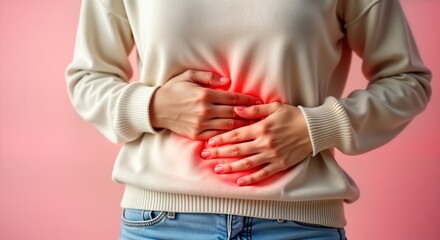 Young woman suffers from abdominal pain. Holds stomach in discomfort. Indoor studio shot. Health care concept. Possible menstrual issues. Woman feels unwell during period. Period cramps cause belly