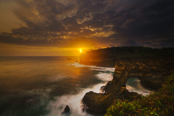 Obraz premium sunset against the sun on the beach at Pantai Karang Bolong Pacitan East Java Indonesia