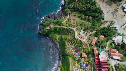 Obraz premium Aerial drone view of coastline with hills and trees, as well as view of coral cliffs and sea with waves from the ocean in Menganti Beach Kebumen Central Java Indonesia