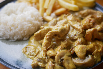 Delicious chicken curry served with fluffy rice and crispy fries