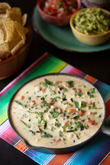Tex-Mex Restaurant Chile Con Queso Dip in cast iron skillet with guacamole, salsa and tortilla chips