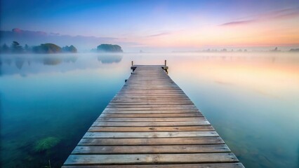 Naklejka premium Serene Sunrise Wooden Dock Extending into Misty Lake Waters at Dawn