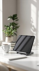 Fototapeta premium Tablet on stand with plants and books in sunlit minimalist workspace