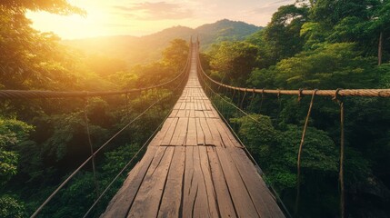 Fototapeta premium Serene View of a Wooden Suspension Bridge Surrounded by Lush Green Forests and Mountains Under a Beautiful Sunset Sky