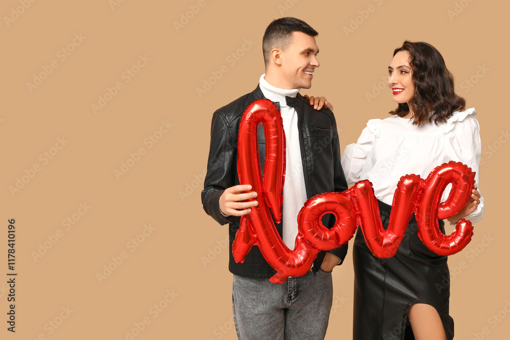 Canvas Prints Loving young couple with balloon in shape of word LOVE on brown background. Celebration of Saint Valentine's Day