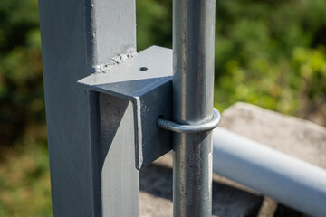 Use U-bolts to fasten the conduit pipe to the angle iron of the steel pole.
