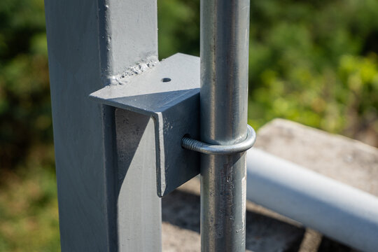 Use U-bolts to fasten the conduit pipe to the angle iron of the steel pole.