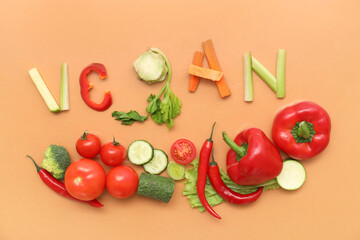 Composition with word VEGAN and different fresh vegetables on color background