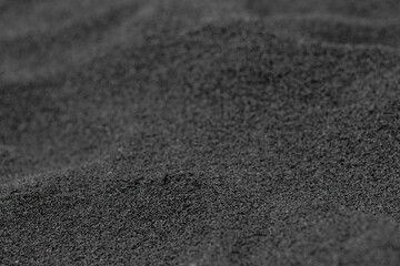 Unique and beautiful black volcanic sand made of lava on the ocean beach. Black sand beach, Big Island, Hawaii, USA.