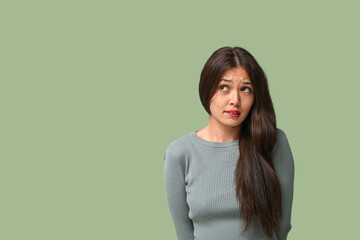 Obraz premium Beautiful young Asian apologizing woman on green background