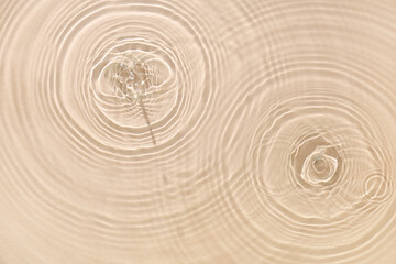 Texture of clean water with splashes on beige background