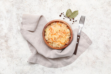 Bowl of tasty sauerkraut with bay leaves and peppercorns on white background. Top view