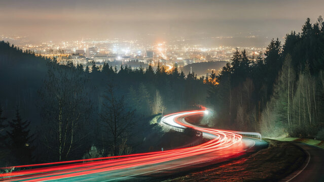 long exposure Car headlights taillights break lights  light trail blur winding around a curvy mountain road in the mountains
