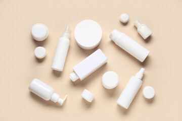 Jars and bottles of cosmetic products on beige background