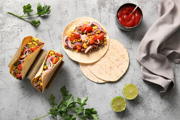 Tasty tacos and ingredients on grey grunge background