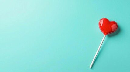 Heart-shaped lollipop. Red heart-shaped lollipop on a turquoise background.