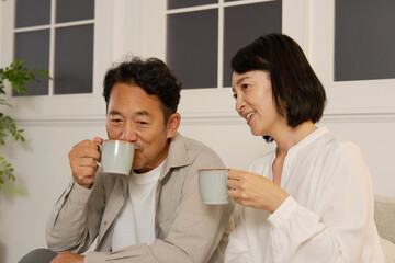 夜のリビングで会話する熟年夫婦