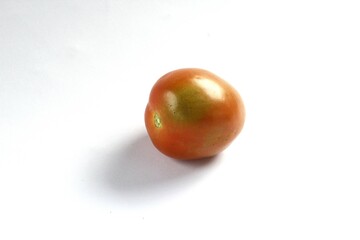 A tomato on a white background. Tomatoes, or Solanum lycopersicum, are a seasonal fruit of the Solanaceae family native to Central and South America. It has a sour and slightly sweet flavor.