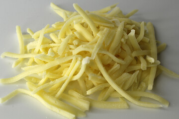 Grated cheddar cheese on a white background