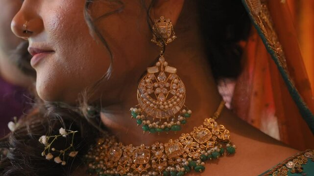 Women dressed in traditional Indian clothes, earrings, neckless, elements of hindu wedding. Close up view