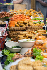 Stalls overflow with an array of Asian delicacies, featuring sizzling kebabs, colorful rolls, and fresh prawns. The atmosphere buzzes with excitement and tempting aromas.