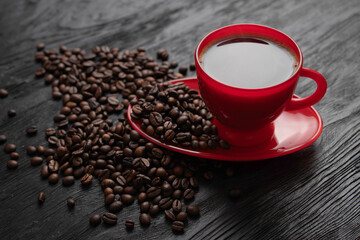 Cup of coffee on a saucer on a black background for breakfast