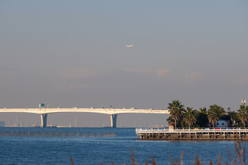 アクララインと羽田空港から離陸する飛行機が見える木更津の青い海