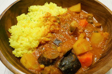 Delicious looking curry with lots of vegetables, yellow saffron rice, steam