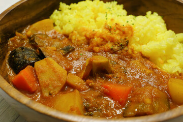 Delicious looking curry with lots of vegetables, yellow saffron rice, steam