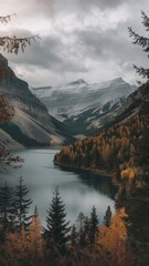 A scenic mountain lake reflects the autumn sky and surrounding forested landscape