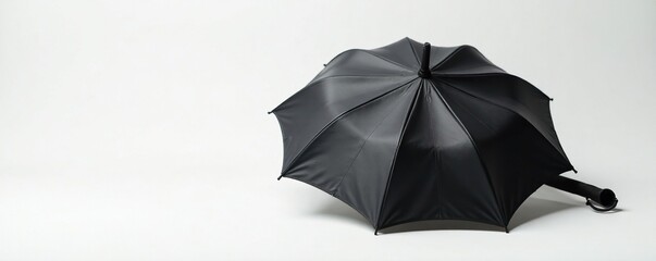 Dark leather umbrella folded on a crisp white surface, folded, leather, neutral