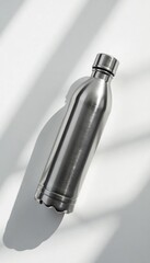 Overhead shot of stainless steel bottle on a white surface with simple shadows, shadow, modern