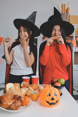 Fototapeta premium friendship, holiday and people concept - group of happy smiling friends in halloween costumes of vampire, devil, witch and cheetah at home party