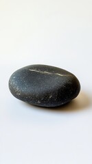 A smooth black stone on a white background, perfect for minimalist and natural design themes.