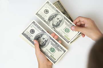 money dollars in hands, counting cash on white table, top view