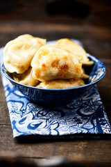 Dumplings with potato and cottage cheese stuffing (pierogi). Wooden background. Copy space.